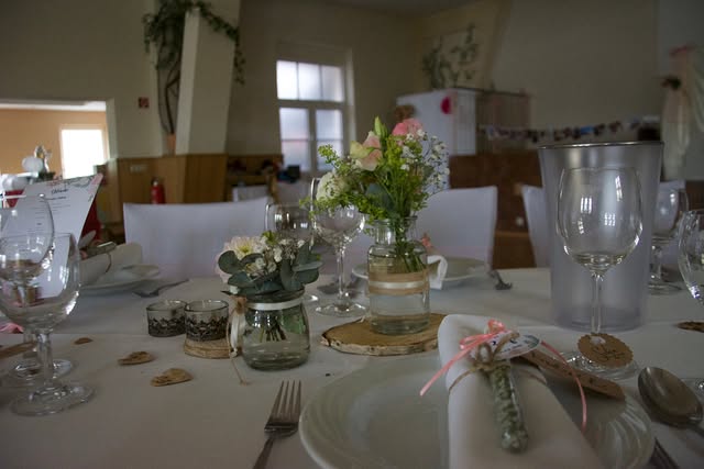 Tischdekoration mit kleinen Blumengestecken bei einer Hochzeitsfeier